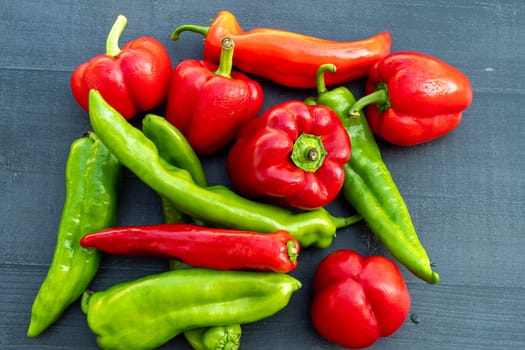 red and green organic peppers on a black table