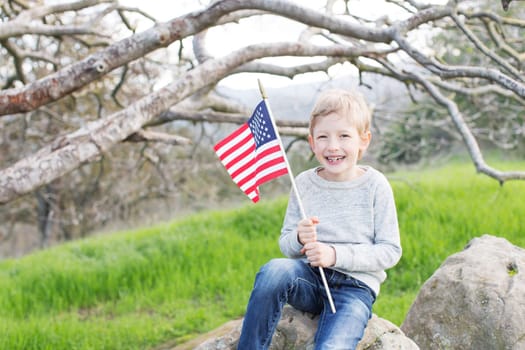 little american boy holding american flag celebrating 4th of july/independence day