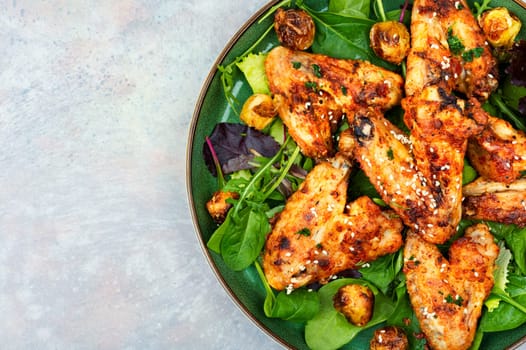 Baked chicken wings with sesame seeds. Chicken meat, space for text