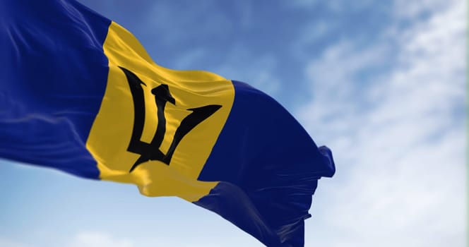 Barbados national flag waving in the wind on a clear day. Blue and yellow flag with a black Triton in the center. 3d illustration render. Rippled Fabric. Selective focus.