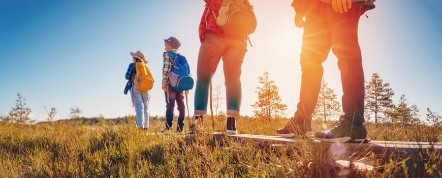 Family walking on the footpath on the bog in Estonia. Concept of the family vacation and tourism.