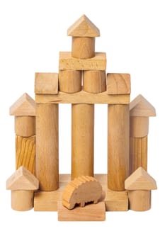Isolated house made of wood. Wooden toy castle made of cubes, cylinders, triangles and a sheep at the entrance. Wooden toy blocks. Macro.