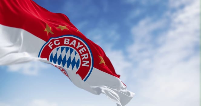 Munich, DE, June 30 2023: Bayern Munich flag waving in the wind on a clear day. German sports club based in Munich. Illustrative editorial 3d illustration render. Waving fabric. Selective focus