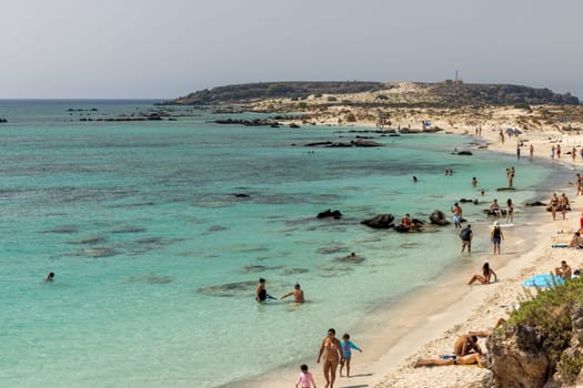 Elafonisi, Crete, Greece - Sept 19, 2021: People relaxing on the famous pink coral beach of Elafonisi on Crete, Mediterannean sea, Greece