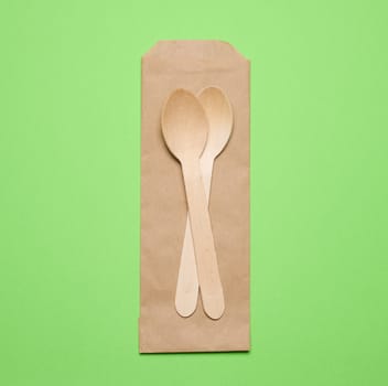 Wooden spoons on a green background, top view