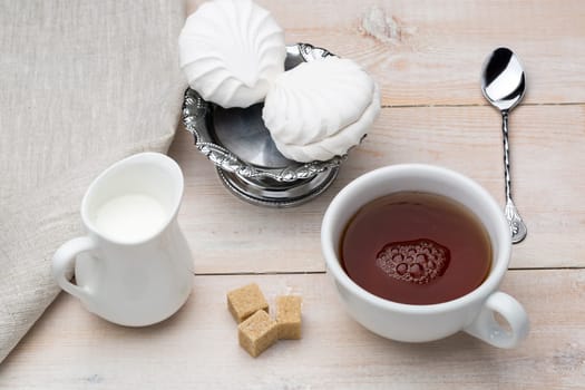 Set of cup black tea and dessert on bright wooden table
