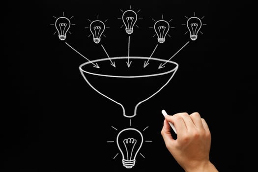 Hand drawing light bulbs and funnel teamwork concept with white chalk on blackboard. Many small ideas add up to a big one.