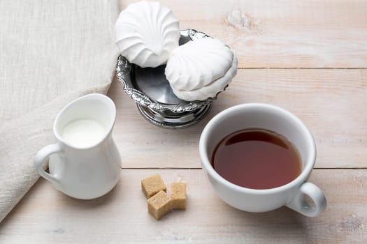 Set of cup black tea and dessert on bright wooden table