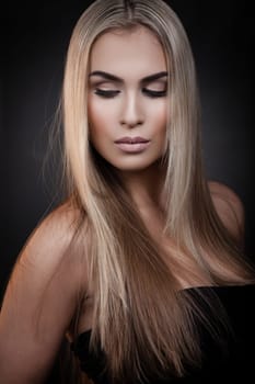 Sexy blond woman posing on dark background