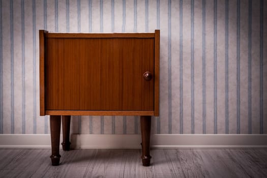 vintage style piece of furniture on a wooden floor and striped wall