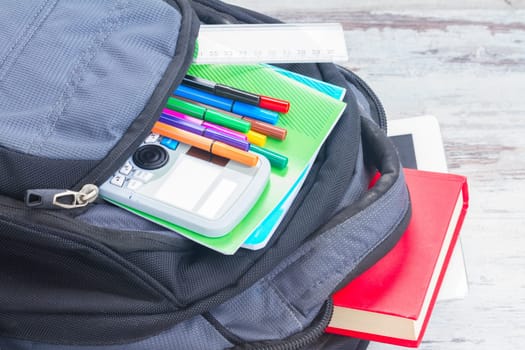 Open school backpack with supplies close up
