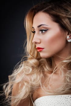 Young blond lady with a beautiful hair on grey background