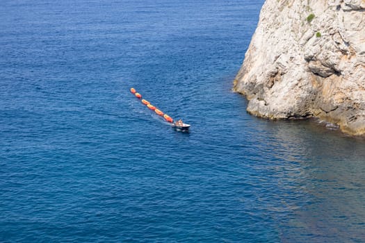 Dubrovnik, Croatia - June 27, 2023: Transportation of colorful kayaks for tourists by water on the Adriatic Sea to the West Harbour next to Fort Lovrijenac and City Walls