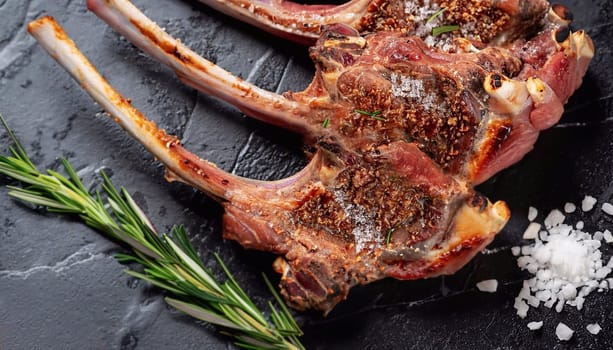 Grilled lamb mutton chop steaks on barbecue, outdoor BBQ grill with fire. Top view.