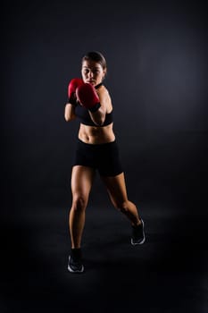 Portrait of female mixed martial arts fighter with a bandage and gloves on her hands.