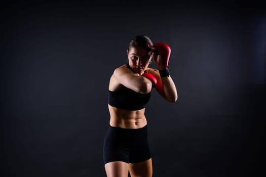 Portrait of female mixed martial arts fighter with a bandage and gloves on her hands.