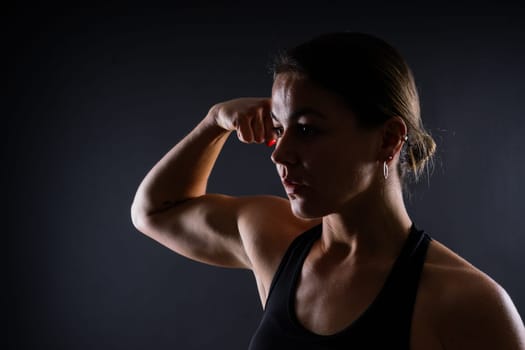 Portrait of female mixed martial arts fighter with a bandage and gloves on her hands.