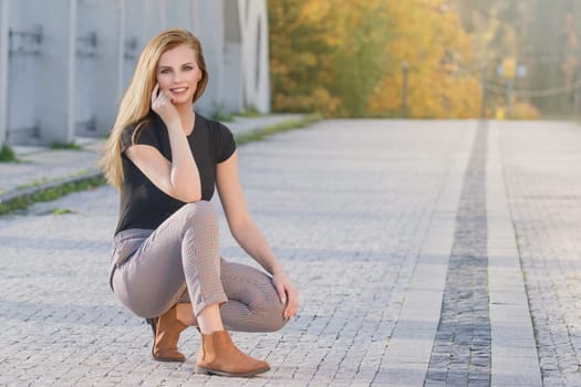 Portrait of beautiful young woman posing on the empty bridge. Horizontally.