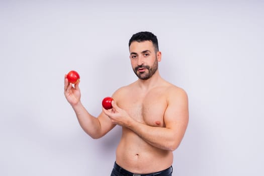 Full isolated studio picture from a young naked man with underwear and tomatoes