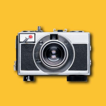 vintage old film camera on yellow background with shadow