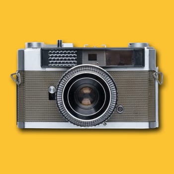 vintage old film camera on yellow background with shadow