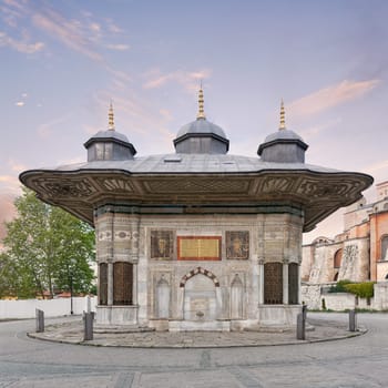 Fountain of Sultan Ahmed III, aka Ahmet Cesmesi, a 17th century public Turkish rococo water fountain, or Sabil, located in the Great Square, near the Imperial Gate of Topkapi Palace, Istanbul, Turkey