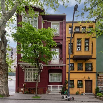 Facade of colorful wooden residential buildings painted in red and orange, with wrought iron window, suited in Kuzguncuk neighborhood, Uskudar district, Istanbul, Turkey