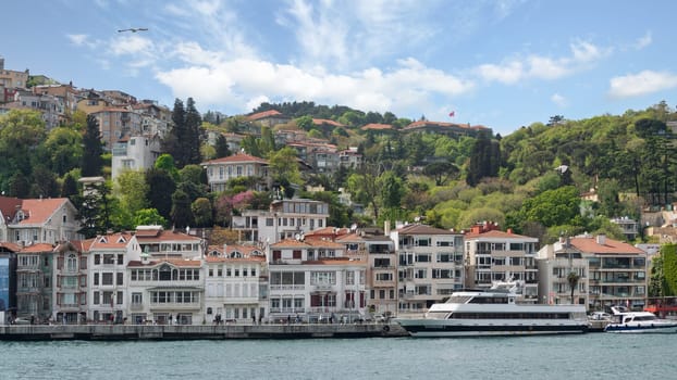 Istanbul, Turkey - May 8, 2023: View from Bosphorus Strait of traditional houses of Arnavutkoy district, in midday light, with the sun shining brightly and the sky a clear blue