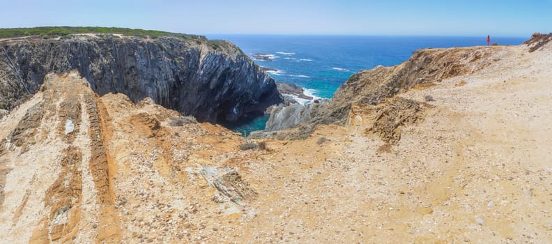 Female visitor contemplating the cliffs of Cabo Sardao coast, Ponta do Cavaleiro, Sao Teotonio, Portugal
