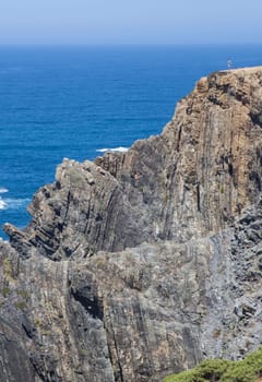 Visitor observing the sea from the top of cliff of Cabo Sardao coast, Ponta do Cavaleiro, Sao Teotonio, Portugal