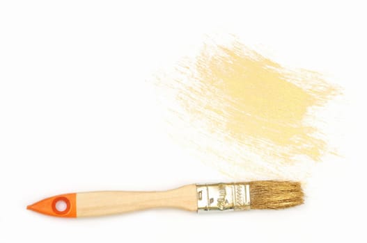 Drawdown of gold paint and brush on the white background