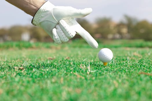 Hand pointing at golf ball