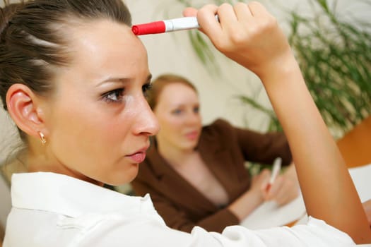 Two business women thinking and making notes