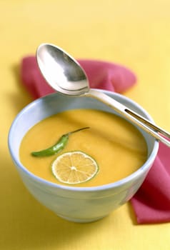 Closeup of bowls of delicious broth with hot pepper and lemon