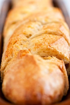 Close up of sliced baguette bread in wooden dish