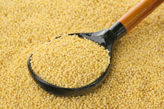 Millet in a wooden spoon