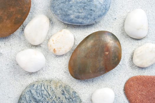 different little stones on white clean sand