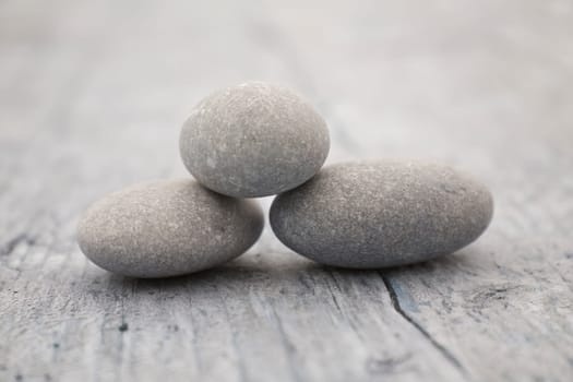 three round and soft stones on a old piece of wood