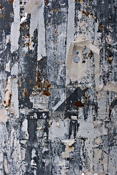 leftovers of torn paper on a metal wall