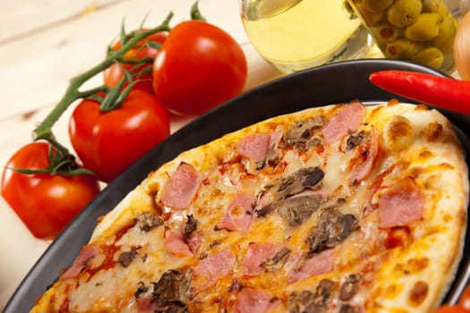 A couple of delicious pizzas, with raw tomatoes, green peppers and mushrooms