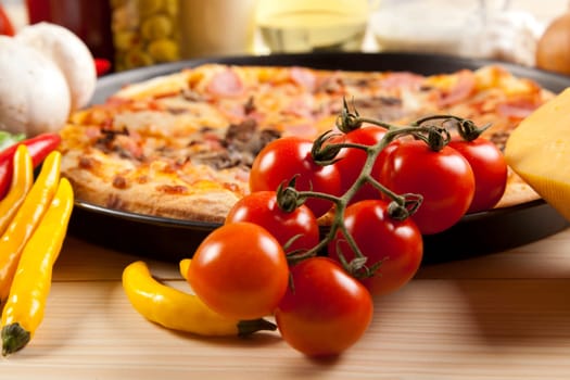A couple of delicious pizzas, with raw tomatoes, green peppers and mushrooms