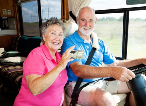Senior couple using a GPS to navigate their motor home on the road.