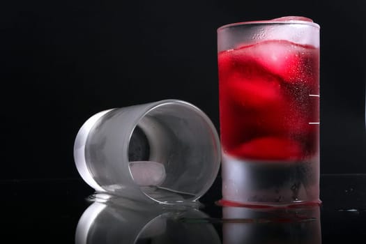 whiskey in glass with ice cube on the mirror