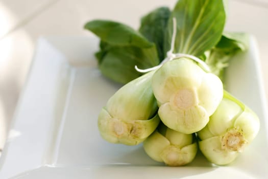 Baby bok choy or Chinese cabbage on a white plate.