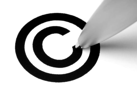Copyright sign with tip of pen, on white.