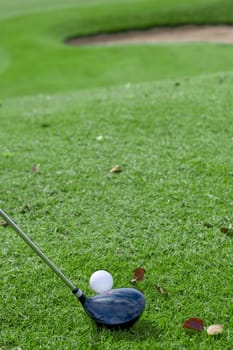 getting ready to hit golf ball of a small hill