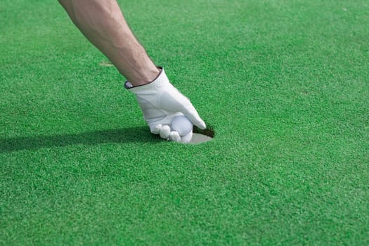 Taking a golf ball out of a hole