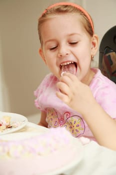 Cute girl testing her birthday cake with cream