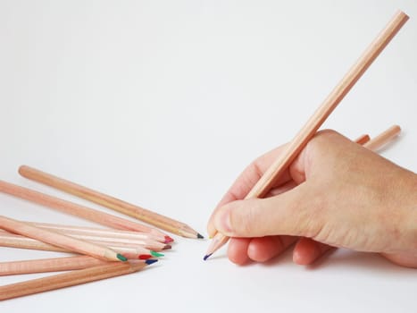 human hand ready to write with color pencils