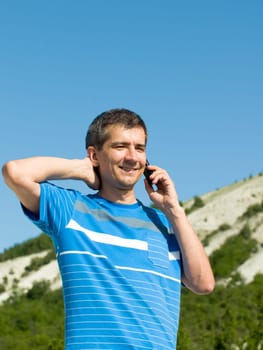 a man is talking on the mobile at the mountains